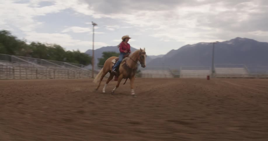 A woman riding a horse on an empty racetrack