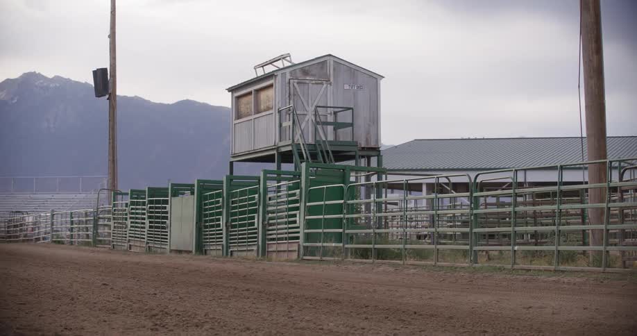 Panorama of a wooden cabin facing a rodeo arena