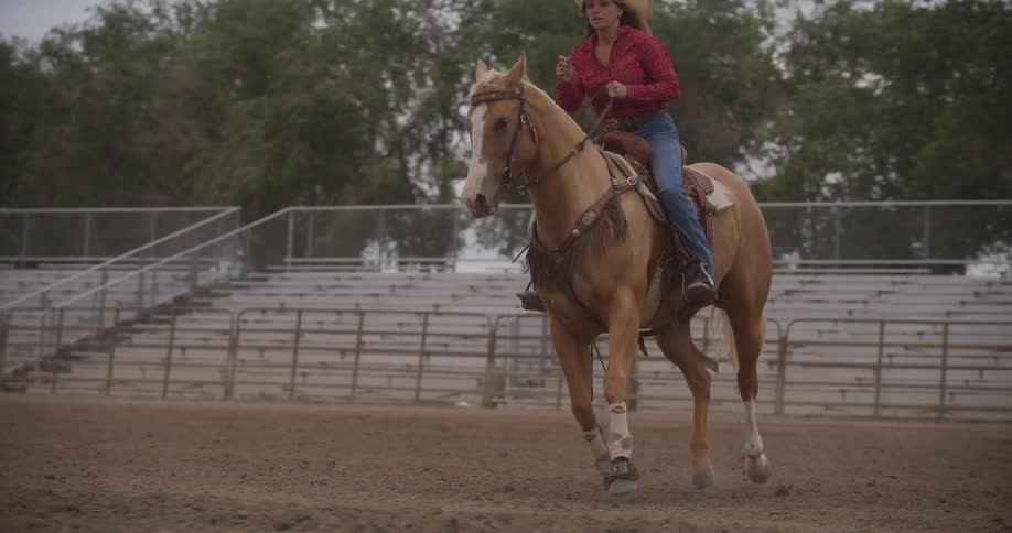 Cowgirl riding a horse in a rodeo arena