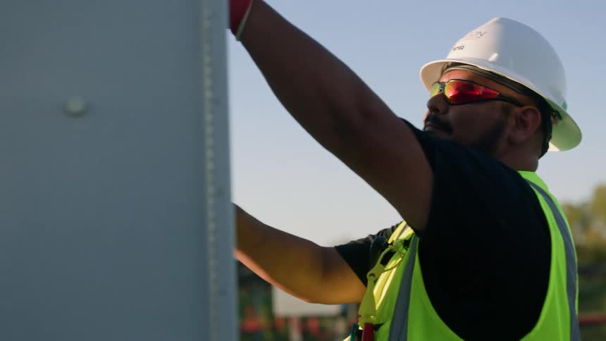 Male construction worker inspecting a power control box