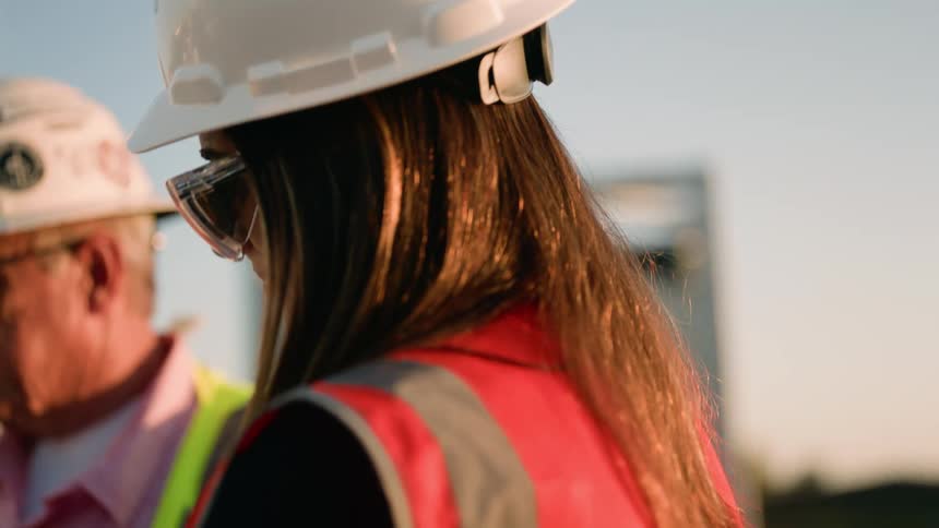 Utility workers wearing safety vests, hard hats and safety googles during electrical box inspection