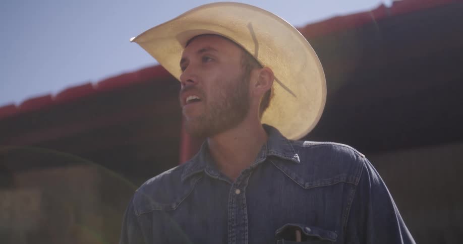 Cowboy wearing a hat looks up