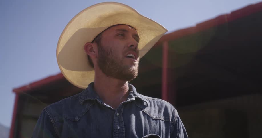 A man in a cowboy hat is sighing