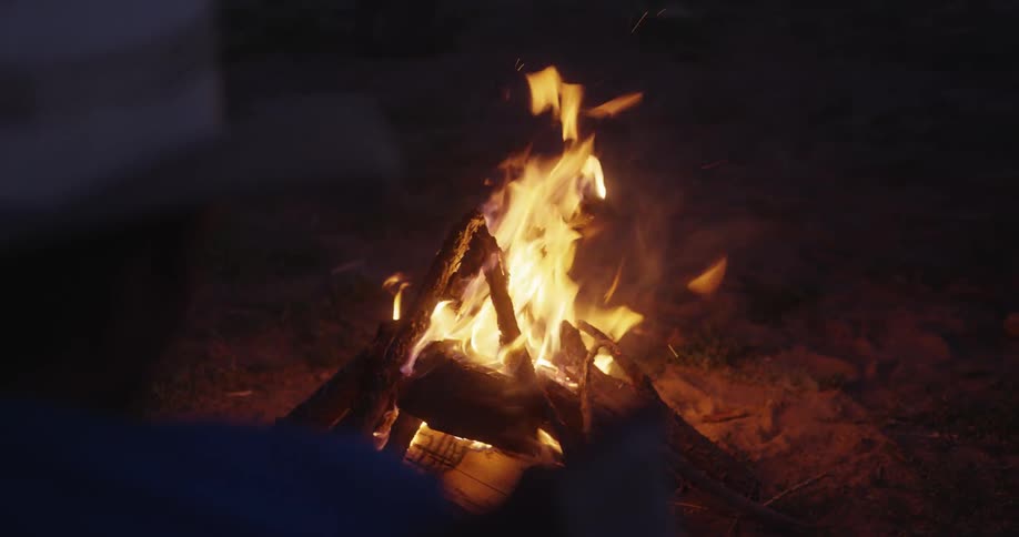 A camp fire burning in the middle of the night