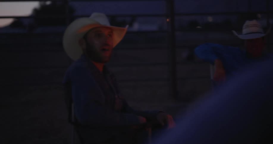 Cowboys sitting and conversing among themselves at night