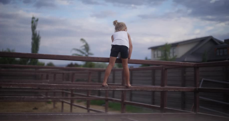 Girl playing over the fences in a stable
