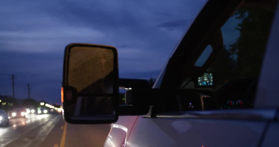 A lady driving on a city road at night
