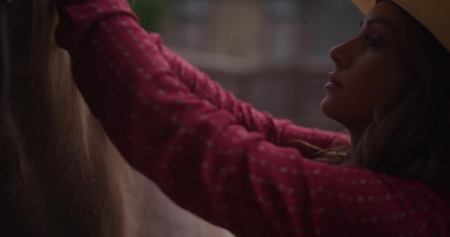 Cowgirl braiding the mane of the horse