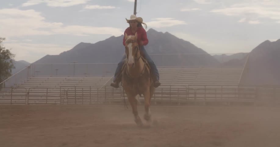 A female riding on a horse at midday