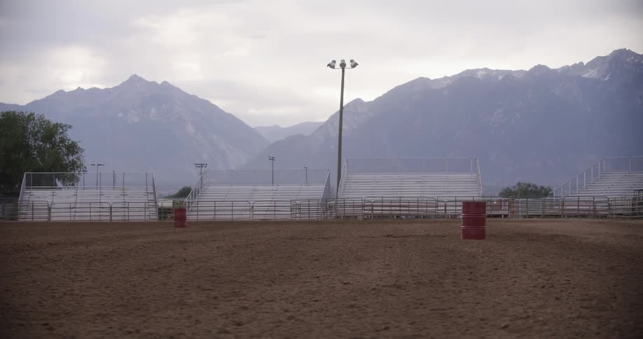 A dirt rodeo arena with white bleachers