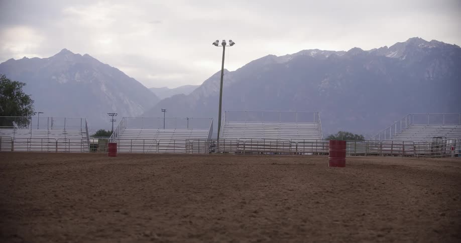 A cattle ranch with fence light and a mountain behind