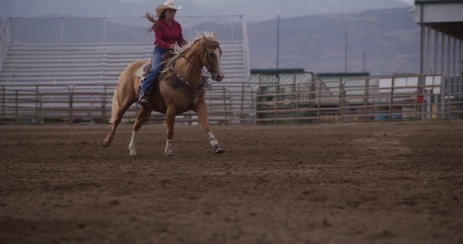 Woman riding a horse in a rodeo arena