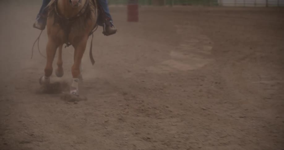 Cowgirl riding a horse in a corral