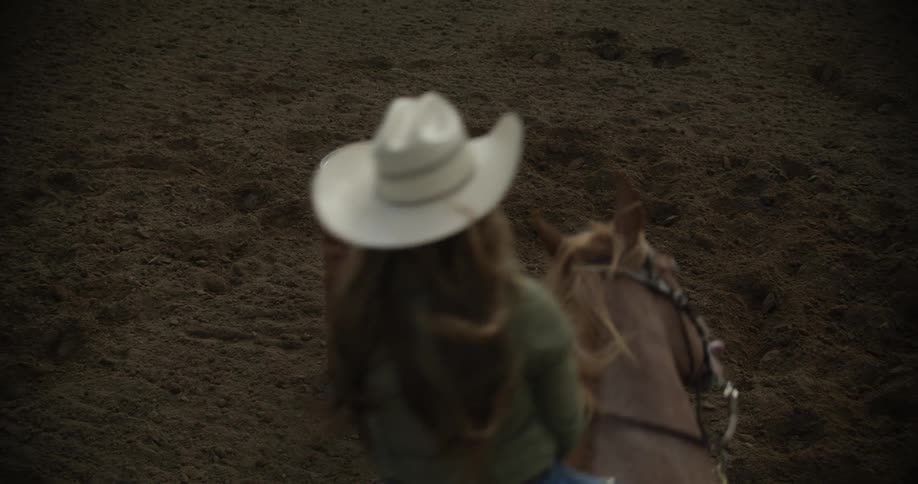 A woman circles a barrel with her horse