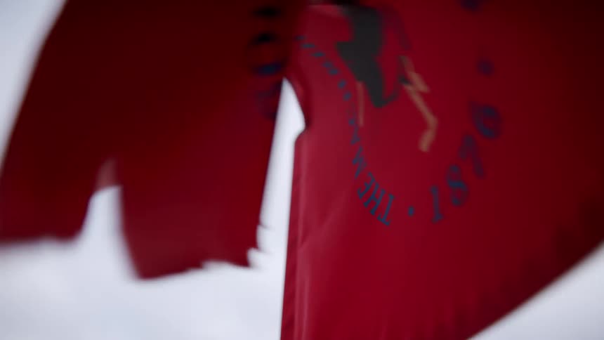 Closeup of a golf flag waving in motion on a cloudy day