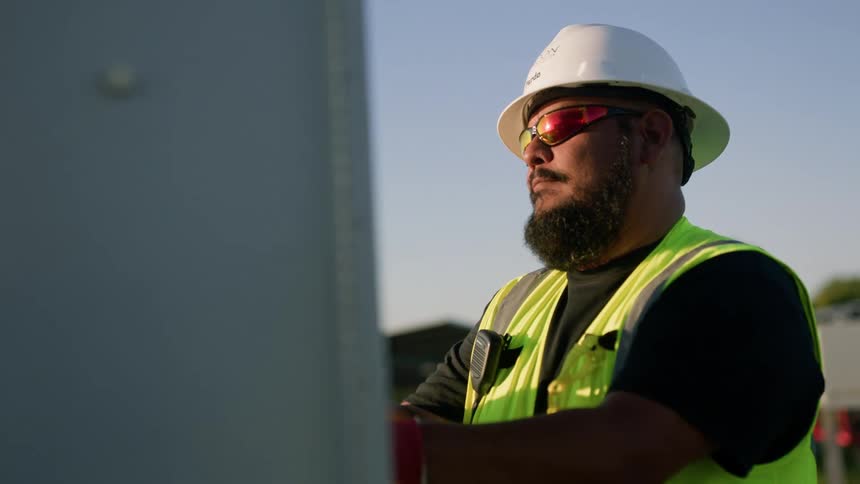 A utility worker opens a power box