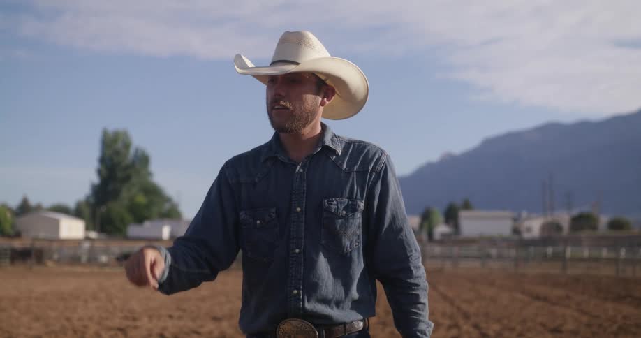 Cowboy in a sand ranch snapping his fingers
