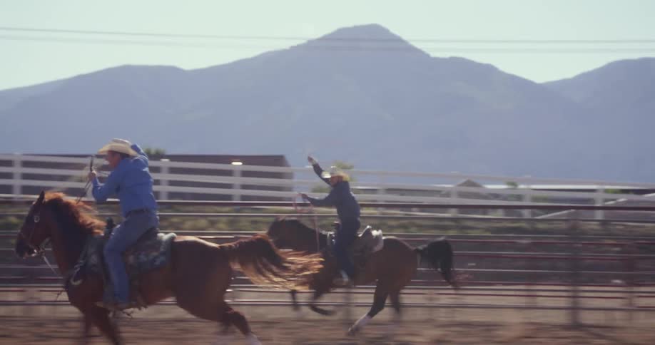 Cowboys riding horses in the rodeo