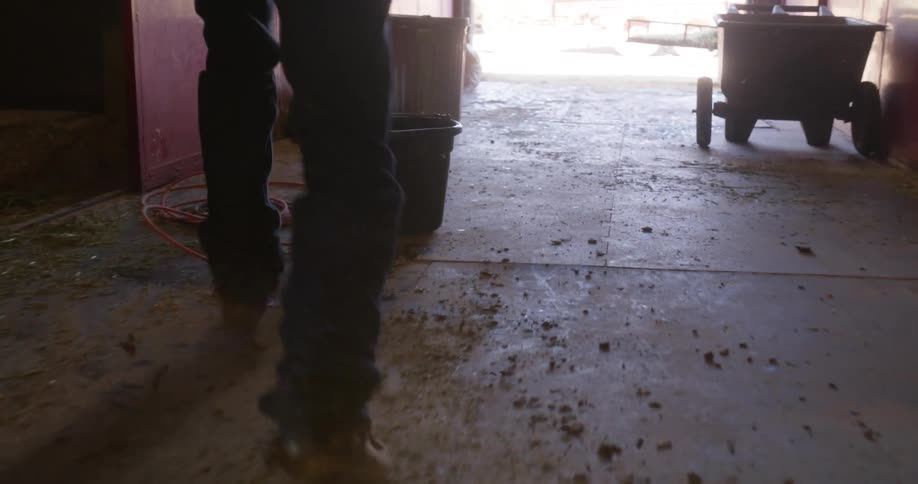 Angry cowboy walks out of a stable trashing the place
