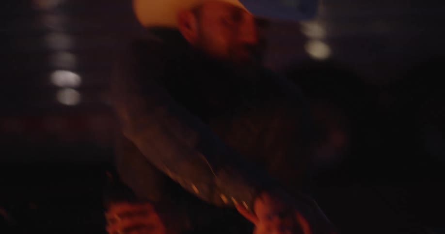 Two men greeting each other while sitting at night