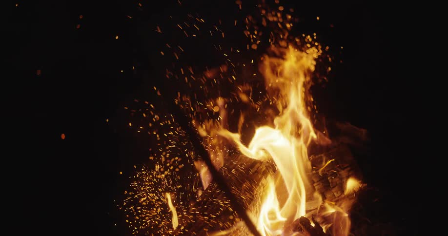 Small campfire with flames and embers during the night