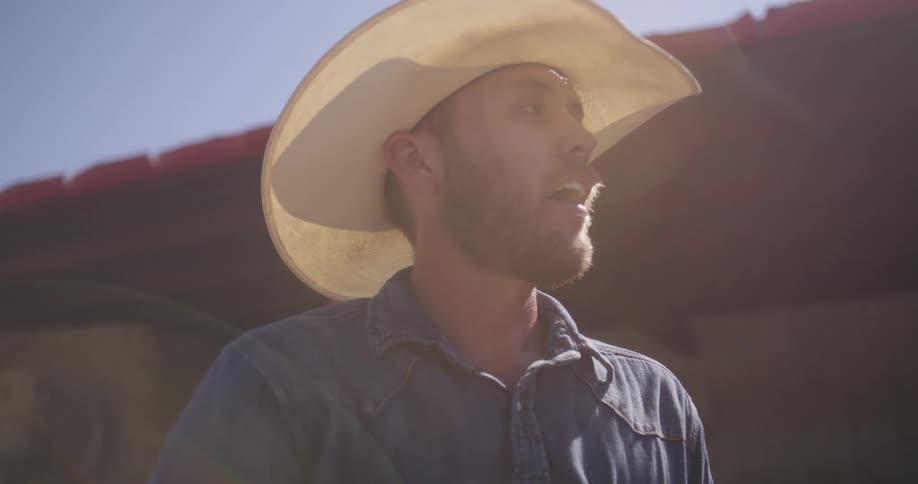 A man wearing a cowboy hat on the hot day