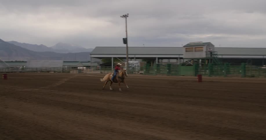 A woman races her horse in the rodeo arena