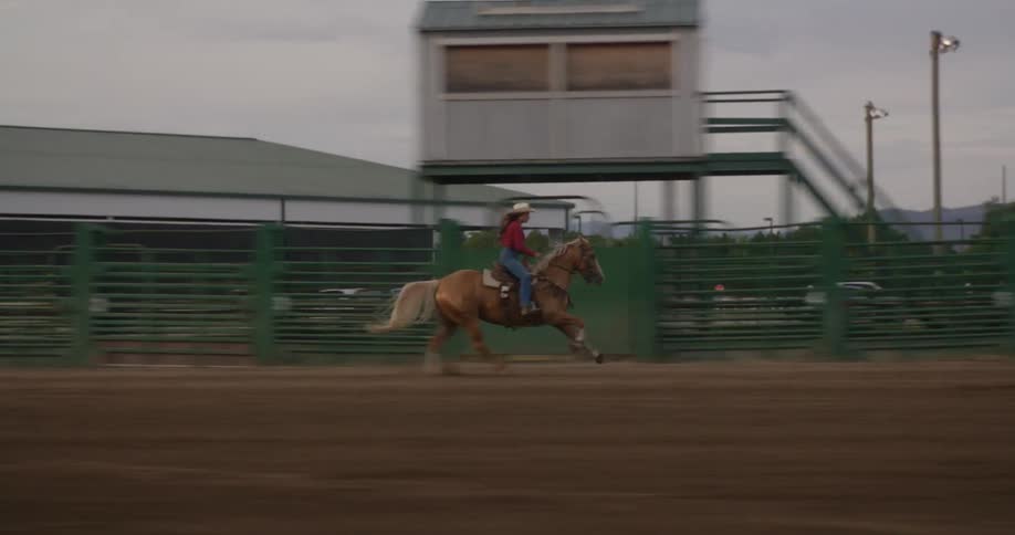 Lady riding a horse on a sandy field during the day
