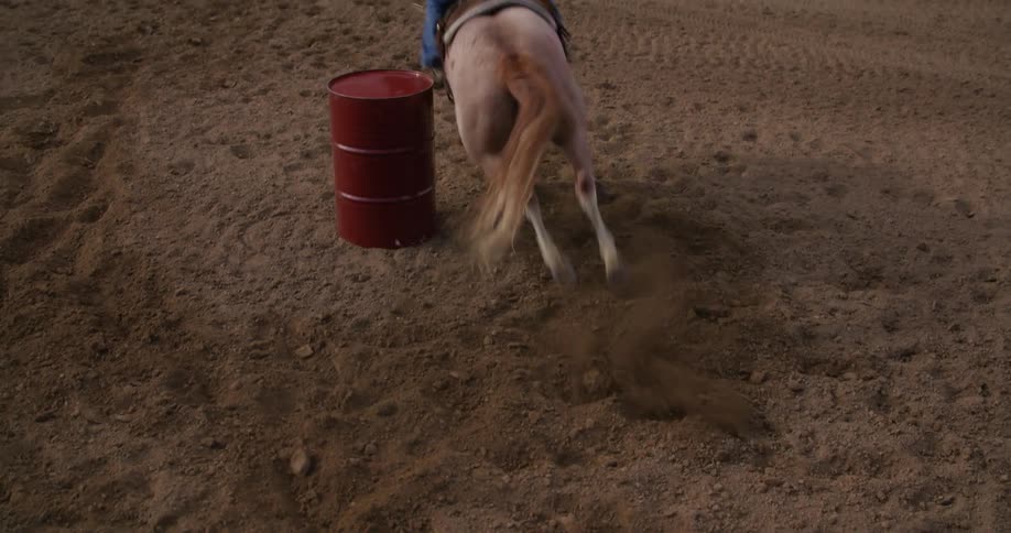 A person races their horse around a barrel