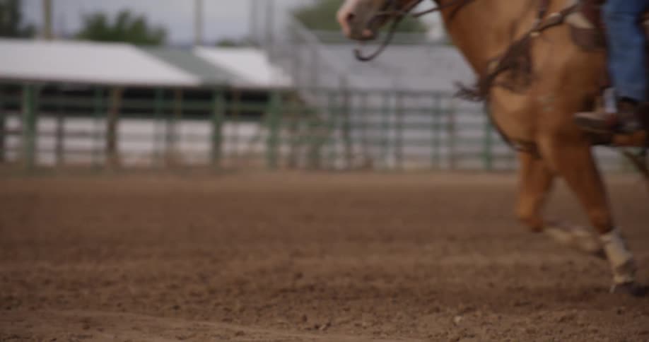 Person rides a horse on a sandy field during the day