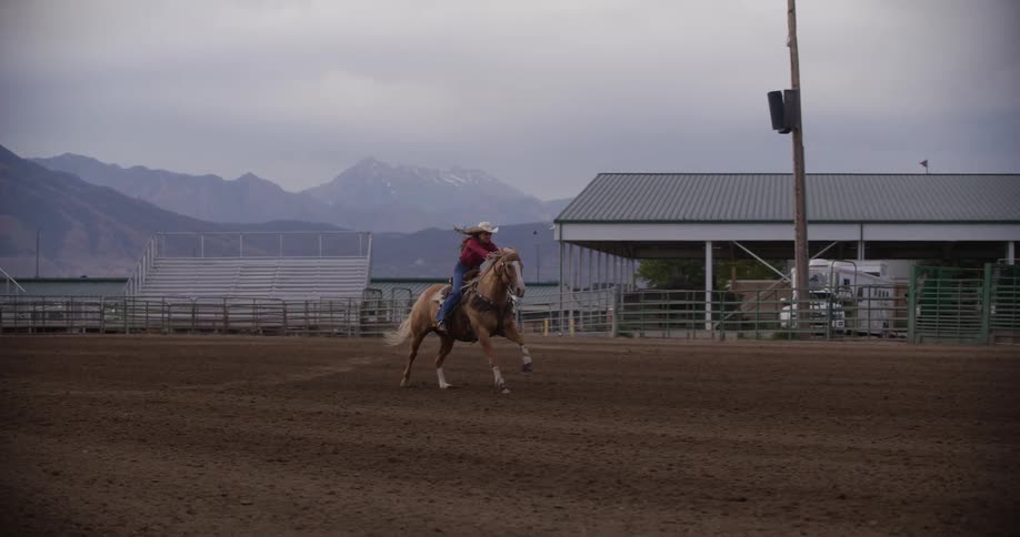 A woman races her horse in the arena