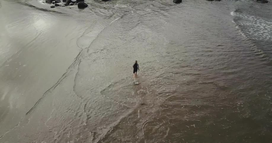 A person is running in the water on the shore below