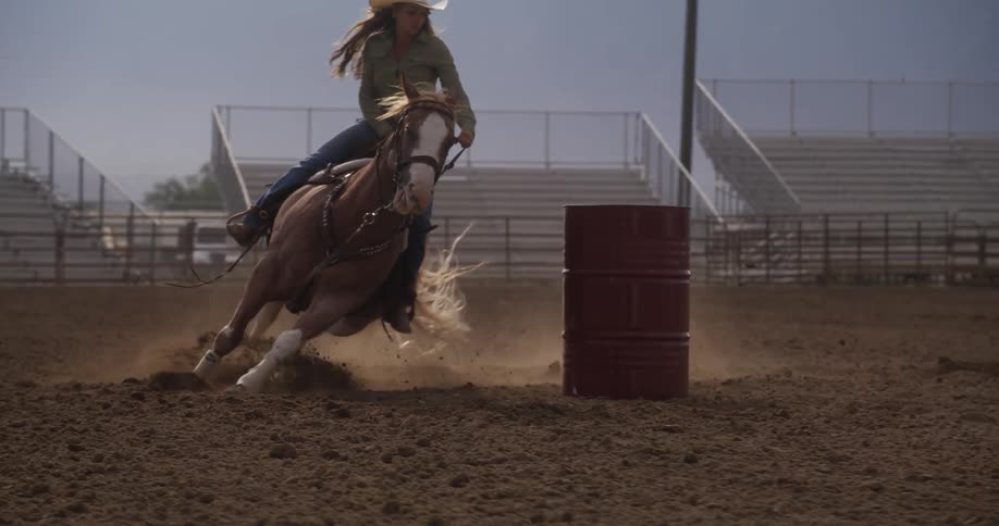 A woman races her horse around barrels