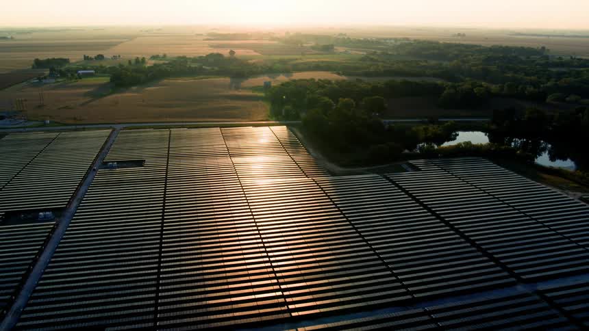 Aerial fly over solar field in the American Midwest at dusk