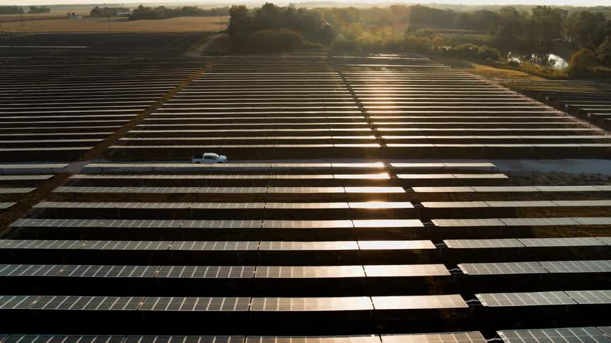 Vehicle passing through a solar panel station in the morning