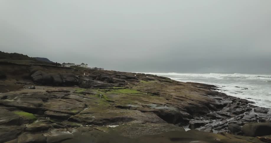 Rocks lead to a shore with rough waves