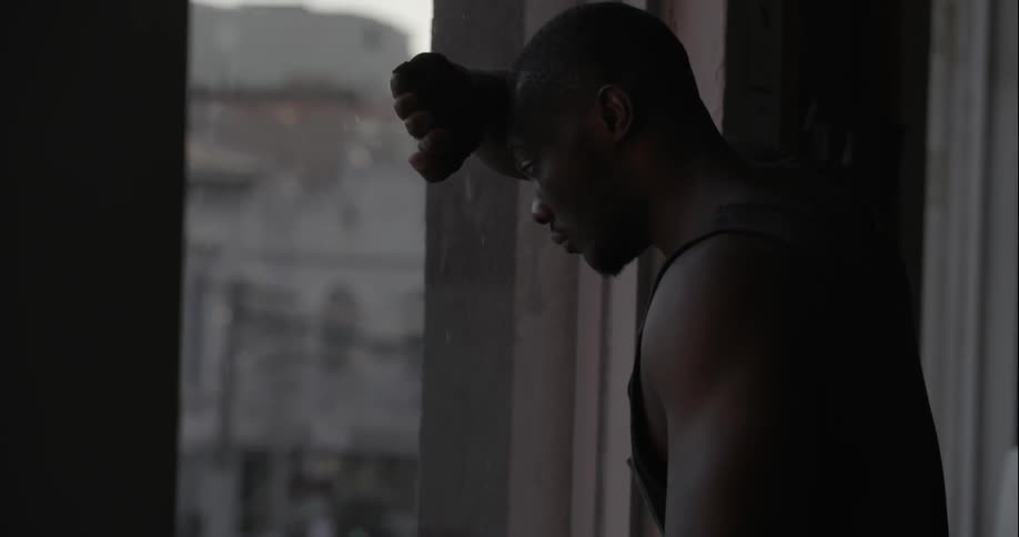 Man looks depressed as he looks out a window