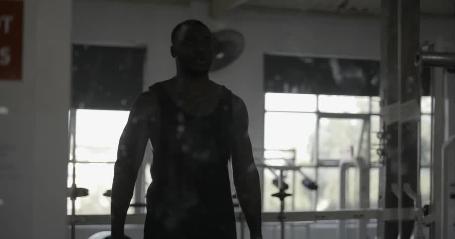 Man picks up a set of dumbbells at the gym