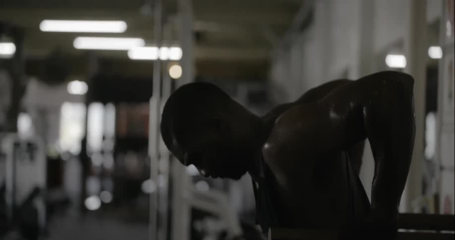 A man is sweating as he works out in a gym