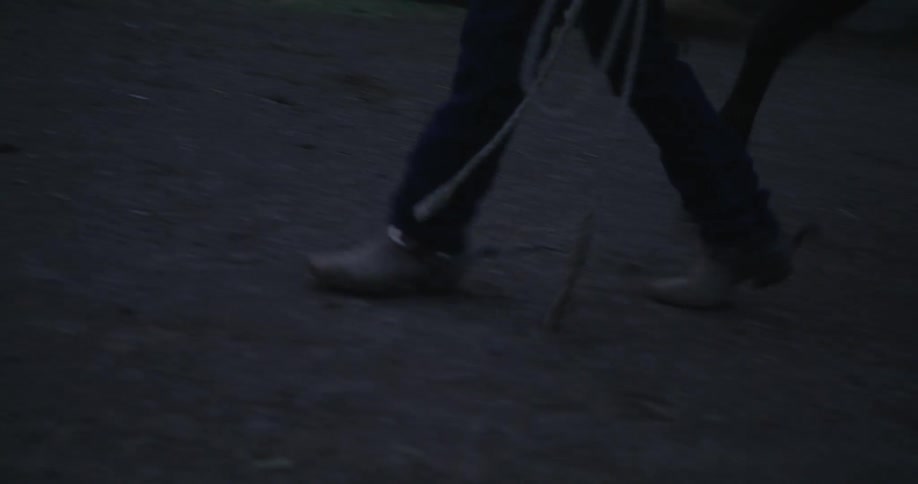 A man leads a horse past the stables