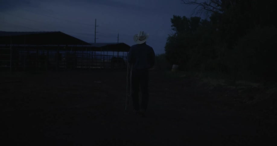 Cowboy walking on the ranch at dawn