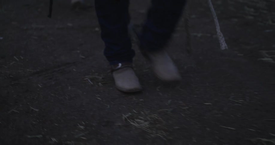 Cowboy walking with a horse on the ranch