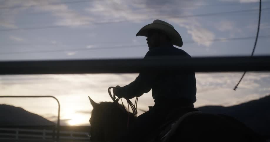 Silhouette of a cowboy riding a horse in the ranch
