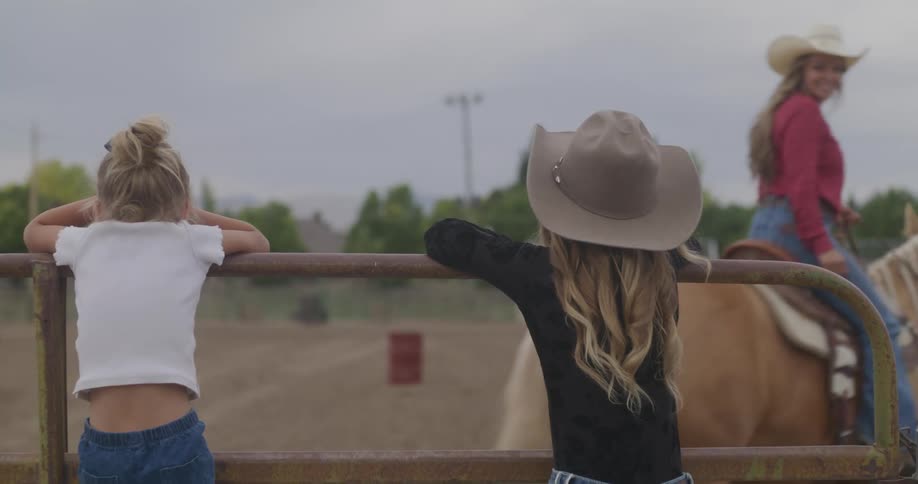 Kids watching their mother ridding on a horse