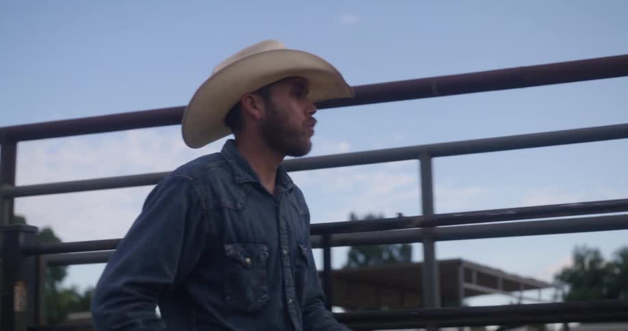 A man wearing a cowboy hat on a horse ranch