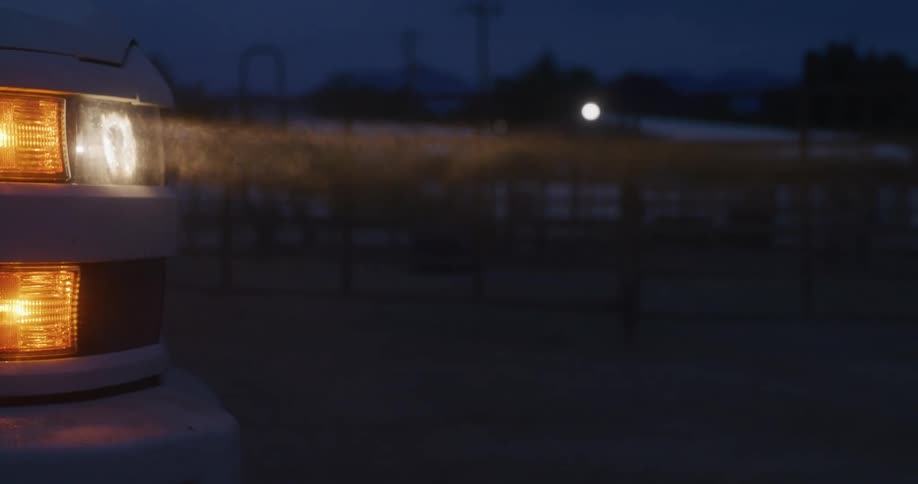 Dust lights up in front of the truck headlights at night