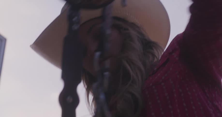Portrait of a cowgirl woman arranging a horse harness