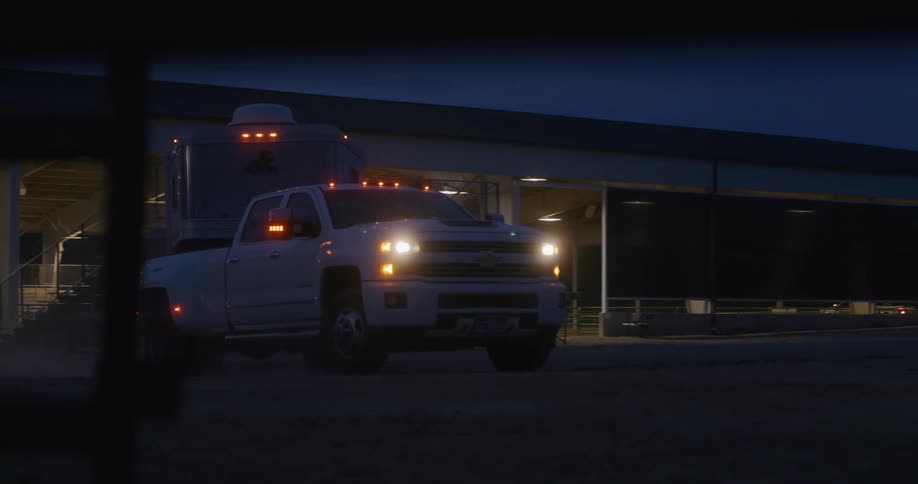Truck towing a trailer parks in a ranch at dawn