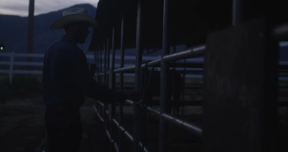 A men untying a rope at the horse stable