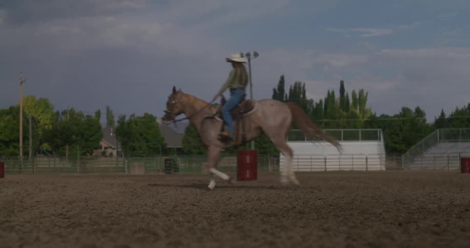 A woman riding a horse in a dirt field